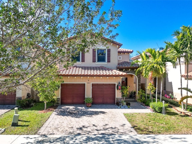 mediterranean / spanish house featuring a garage and a front lawn