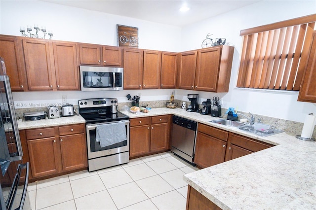 kitchen with light tile patterned flooring, appliances with stainless steel finishes, and sink