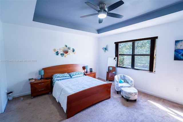 bedroom with carpet, ceiling fan, and a tray ceiling