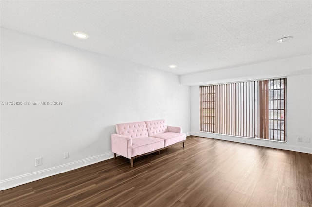 unfurnished room featuring dark wood-type flooring and a textured ceiling