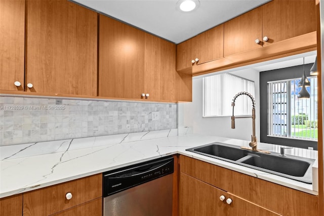 kitchen with stainless steel dishwasher, light stone countertops, sink, and tasteful backsplash