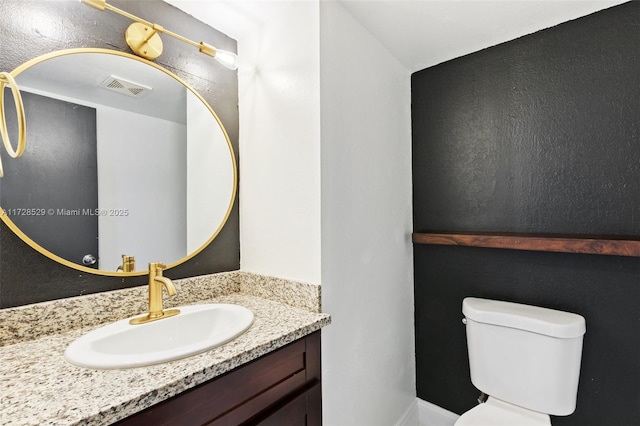 bathroom featuring toilet and vanity