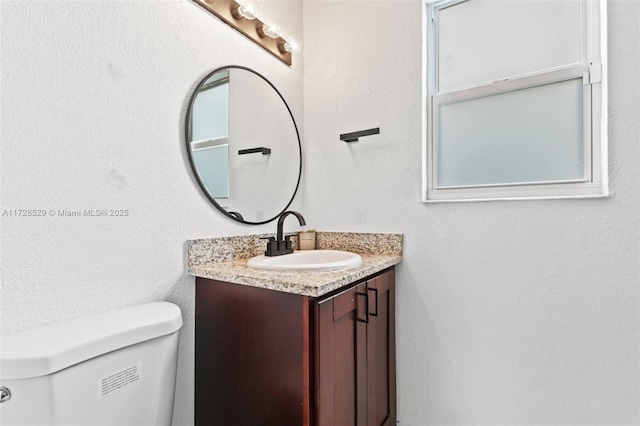 bathroom featuring toilet and vanity