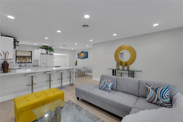 living room with sink and light hardwood / wood-style flooring