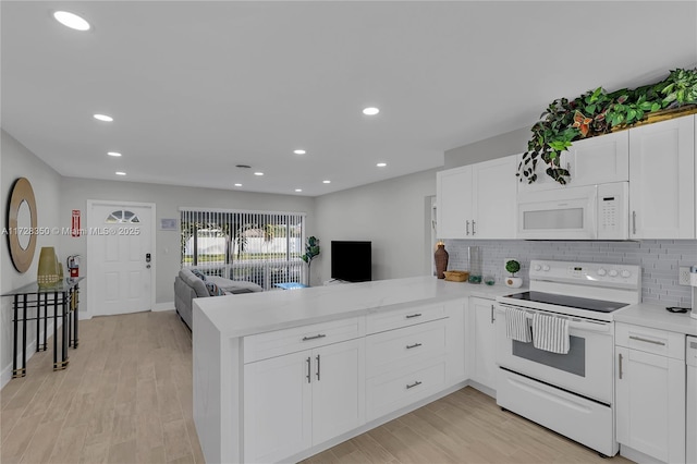 kitchen with white cabinets, kitchen peninsula, tasteful backsplash, and white appliances