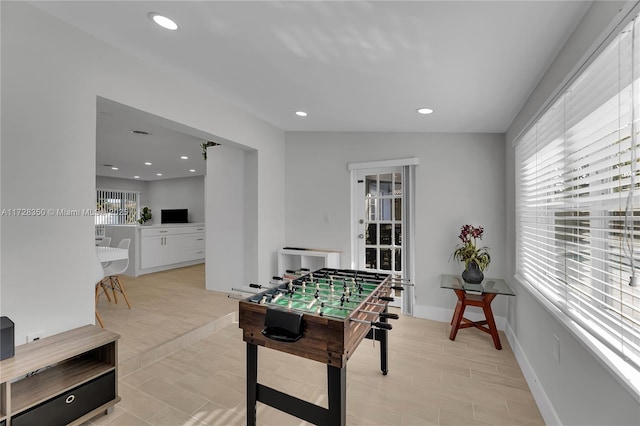 recreation room featuring vaulted ceiling and a wealth of natural light