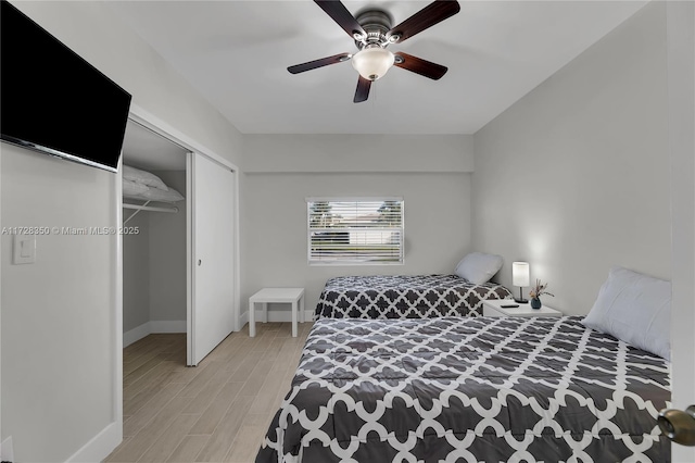 bedroom featuring light wood-type flooring, ceiling fan, and a closet