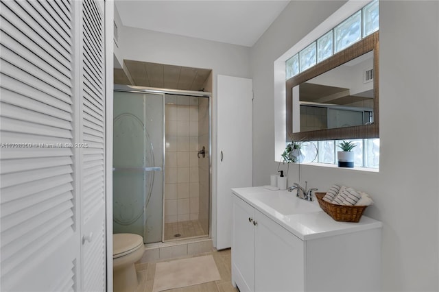 bathroom featuring tile patterned floors, toilet, an enclosed shower, and vanity