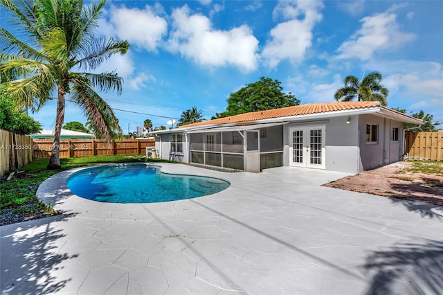 view of swimming pool with french doors, a patio area, and a sunroom