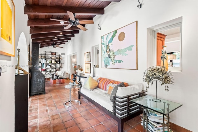 tiled living room featuring ceiling fan, wooden ceiling, and lofted ceiling with beams