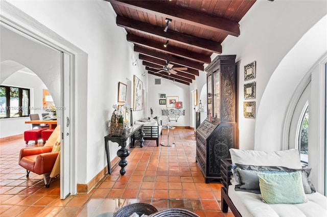 hall featuring wooden ceiling, tile patterned flooring, plenty of natural light, and vaulted ceiling with beams