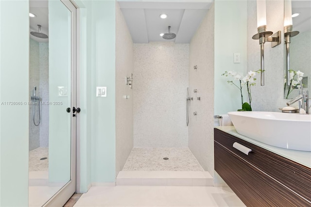 bathroom with vanity and tiled shower