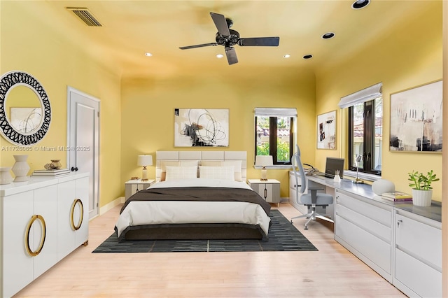 bedroom with ceiling fan, built in desk, and light wood-type flooring