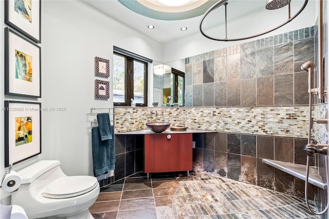 bathroom with toilet, a shower, backsplash, and vanity