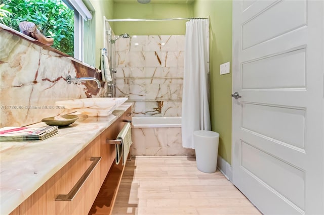 bathroom with wood-type flooring, vanity, and shower / bath combo with shower curtain