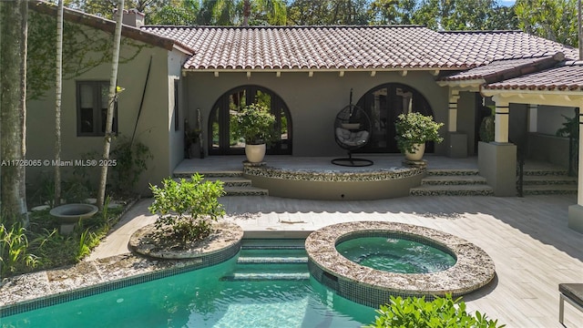 rear view of house with a pool with hot tub