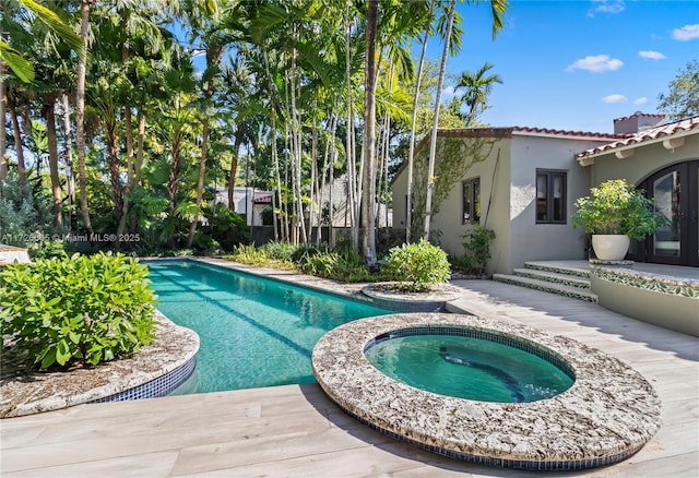 view of swimming pool with an in ground hot tub