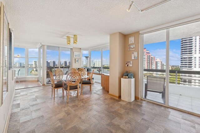 3600 Mystic Pointe Unit 1801, Aventura, FL 33180 - dining space featuring a view of skyline, expansive windows, a textured ceiling, and stone finish flooring