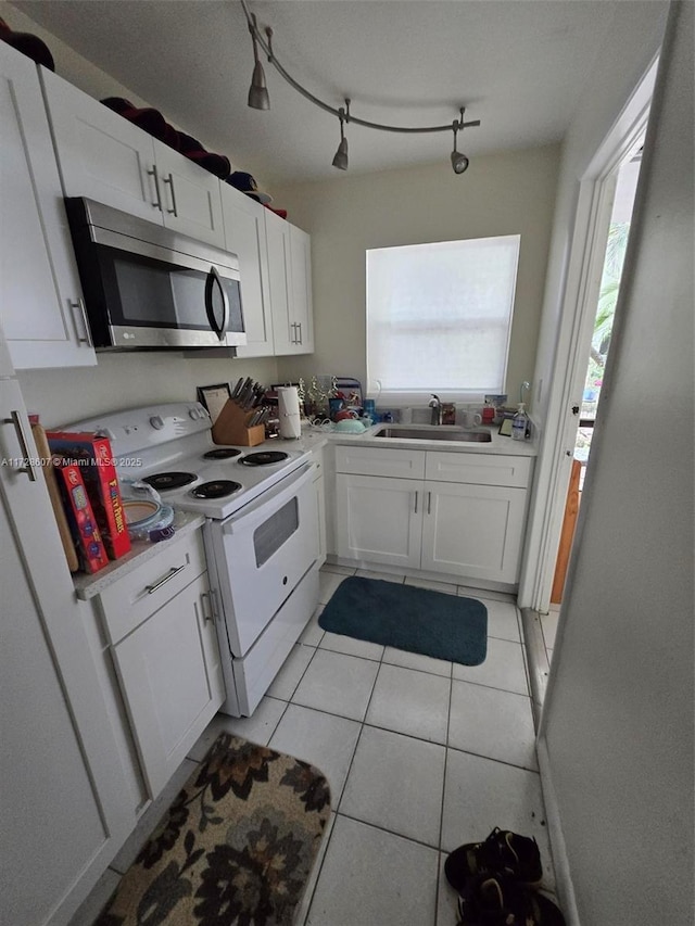 kitchen with white cabinets, white electric range, sink, and light tile patterned floors