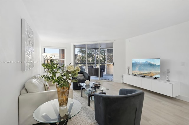 living room with floor to ceiling windows and light wood-type flooring