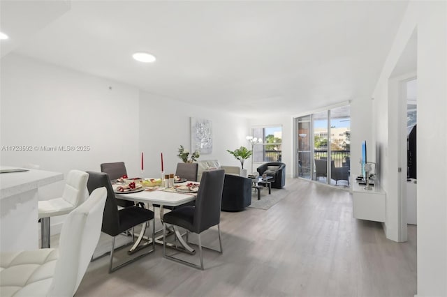 dining room featuring a wall of windows and hardwood / wood-style flooring