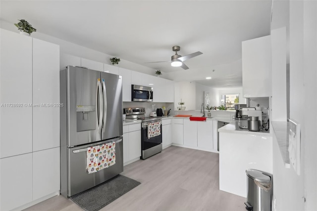 kitchen with ceiling fan, kitchen peninsula, light hardwood / wood-style flooring, stainless steel appliances, and white cabinets