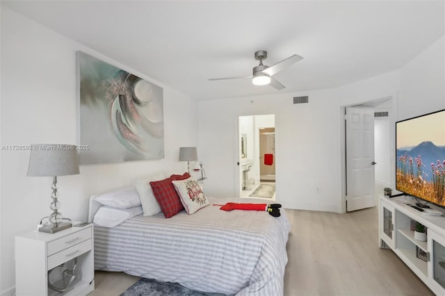 bedroom with ceiling fan, connected bathroom, and light hardwood / wood-style flooring