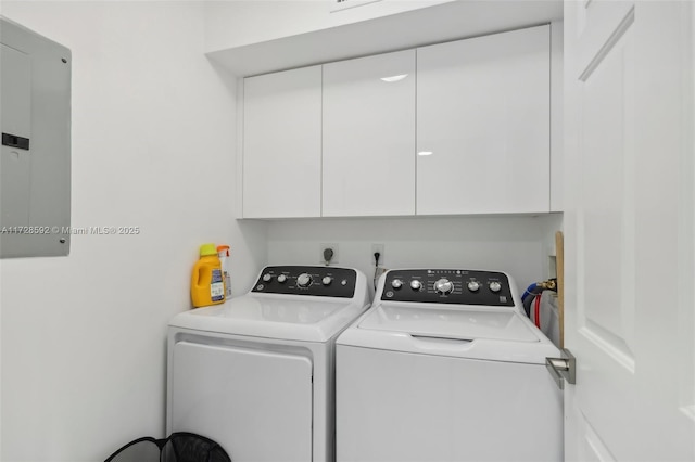 clothes washing area with cabinets, washer and dryer, and electric panel