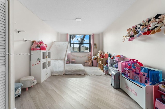 rec room with a textured ceiling and light hardwood / wood-style floors