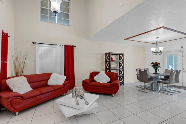 living room with a chandelier, light tile patterned flooring, and a textured ceiling