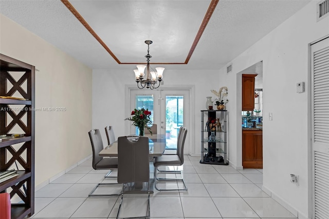 dining room featuring french doors, a textured ceiling, a notable chandelier, and light tile patterned flooring