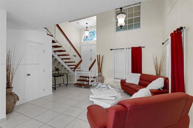 tiled living room with a high ceiling and a textured ceiling