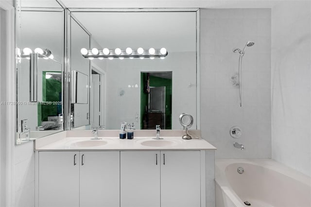 bathroom with tiled shower / bath combo and vanity