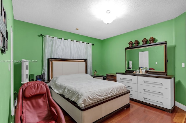 bedroom with a textured ceiling and hardwood / wood-style flooring