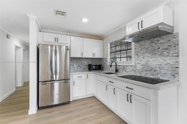 kitchen featuring black appliances, ornamental molding, under cabinet range hood, and a sink