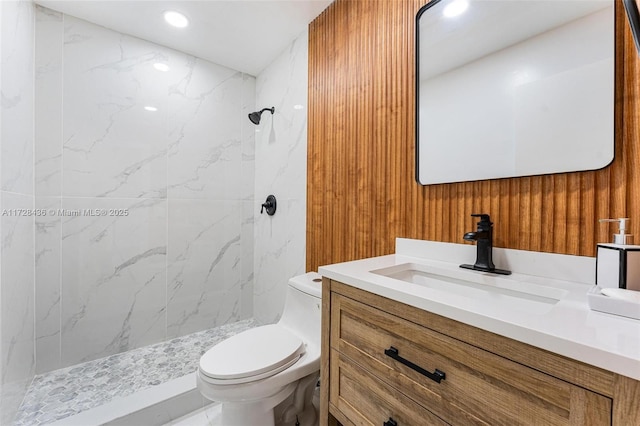 bathroom with toilet, a marble finish shower, vanity, and recessed lighting