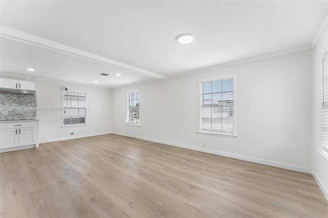 unfurnished living room featuring ornamental molding, a healthy amount of sunlight, and light hardwood / wood-style floors