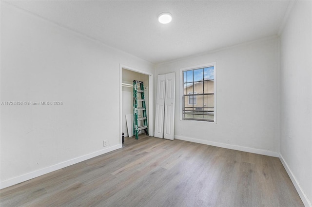 unfurnished room with wood finished floors and baseboards