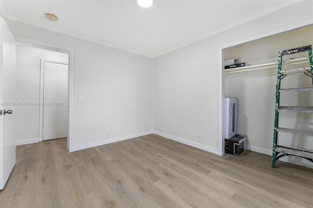 unfurnished bedroom with ornamental molding, baseboards, a closet, and wood finished floors