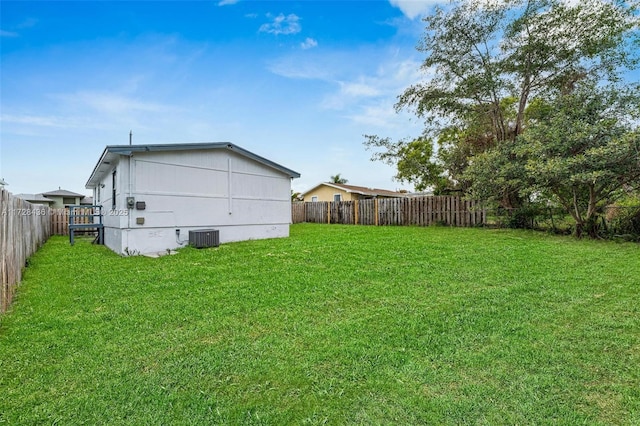 view of yard with central air condition unit and a fenced backyard