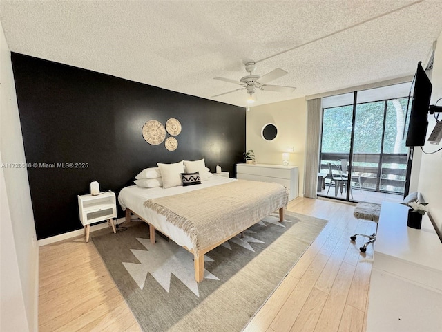 bedroom with ceiling fan, floor to ceiling windows, access to outside, light hardwood / wood-style flooring, and a textured ceiling