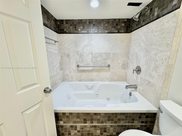 bathroom with toilet and tiled shower / bath