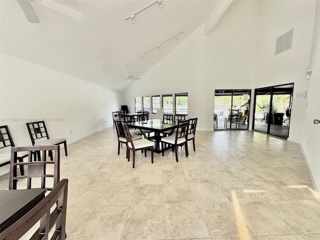 dining room with ceiling fan, a high ceiling, and track lighting