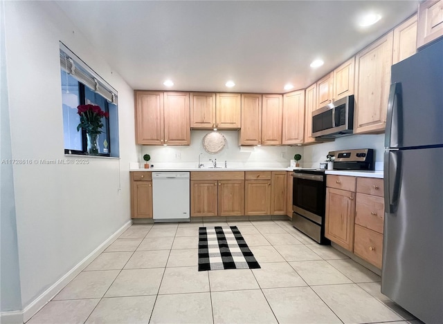 kitchen featuring light tile patterned flooring, stainless steel appliances, light brown cabinets, and sink