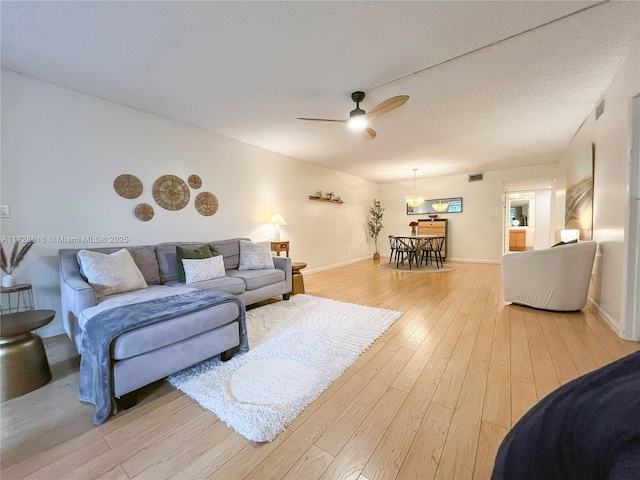 living room featuring ceiling fan and light hardwood / wood-style floors