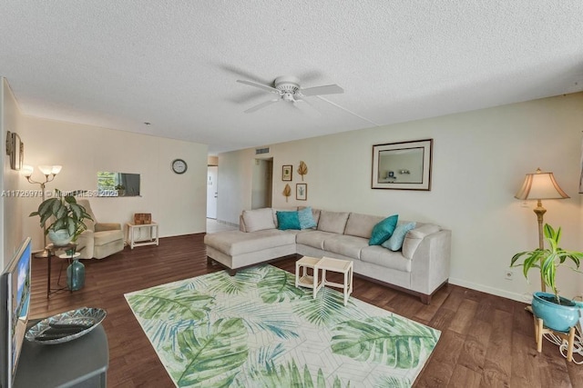 living room with a textured ceiling, dark wood-type flooring, and ceiling fan