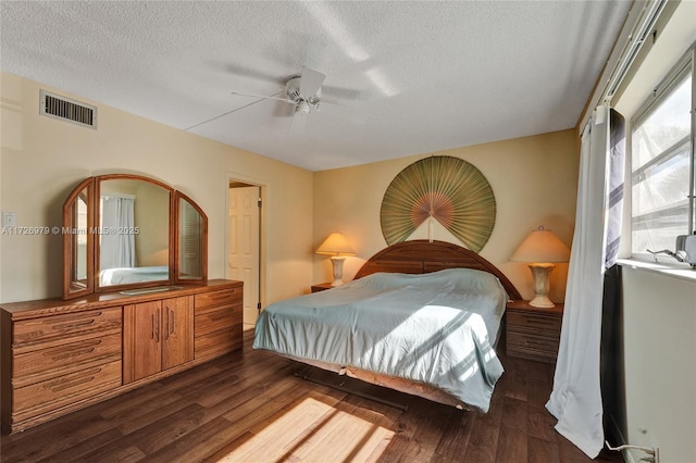 bedroom featuring ceiling fan, a textured ceiling, and dark hardwood / wood-style floors