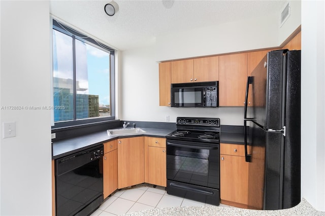 kitchen featuring sink, a textured ceiling, light tile patterned floors, and black appliances