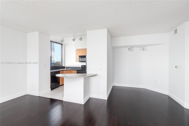 kitchen featuring a kitchen breakfast bar, a textured ceiling, black appliances, and kitchen peninsula