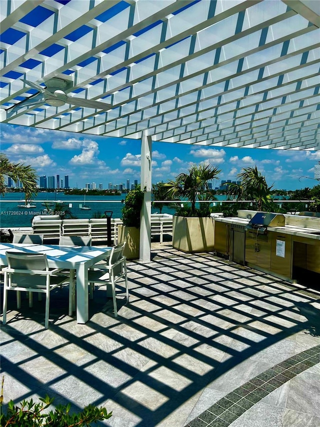 view of patio / terrace featuring ceiling fan, grilling area, a water view, and a pergola